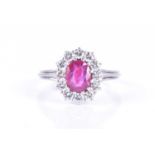 A platinum, diamond, and ruby cluster ringset with a mixed oval-cut ruby, possibly Burmese, within a