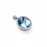 A 9ct yellow gold blue topaz and diamond pendant, the central oval blue topaz weighing 5.73 carat