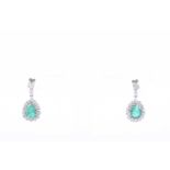 A pair of white gold, diamond, and emerald drop earringseach set with a mixed pear-cut emerald,