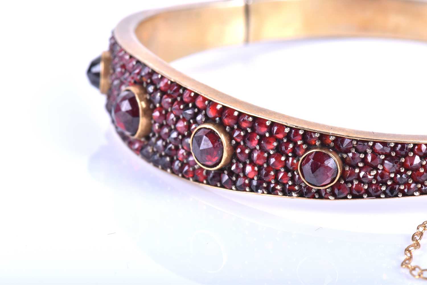 A late Victorian garnet bracelet, the gilt metal hinged bangle set with five collet-set rose-cut - Image 3 of 8