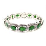 A platinum, jade and diamond bracelet, the central oval pieces of jade surrounded by diamonds. 32.