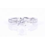 A white gold and diamond ringcentred with a round brilliant-cut diamond of approximately 1.07