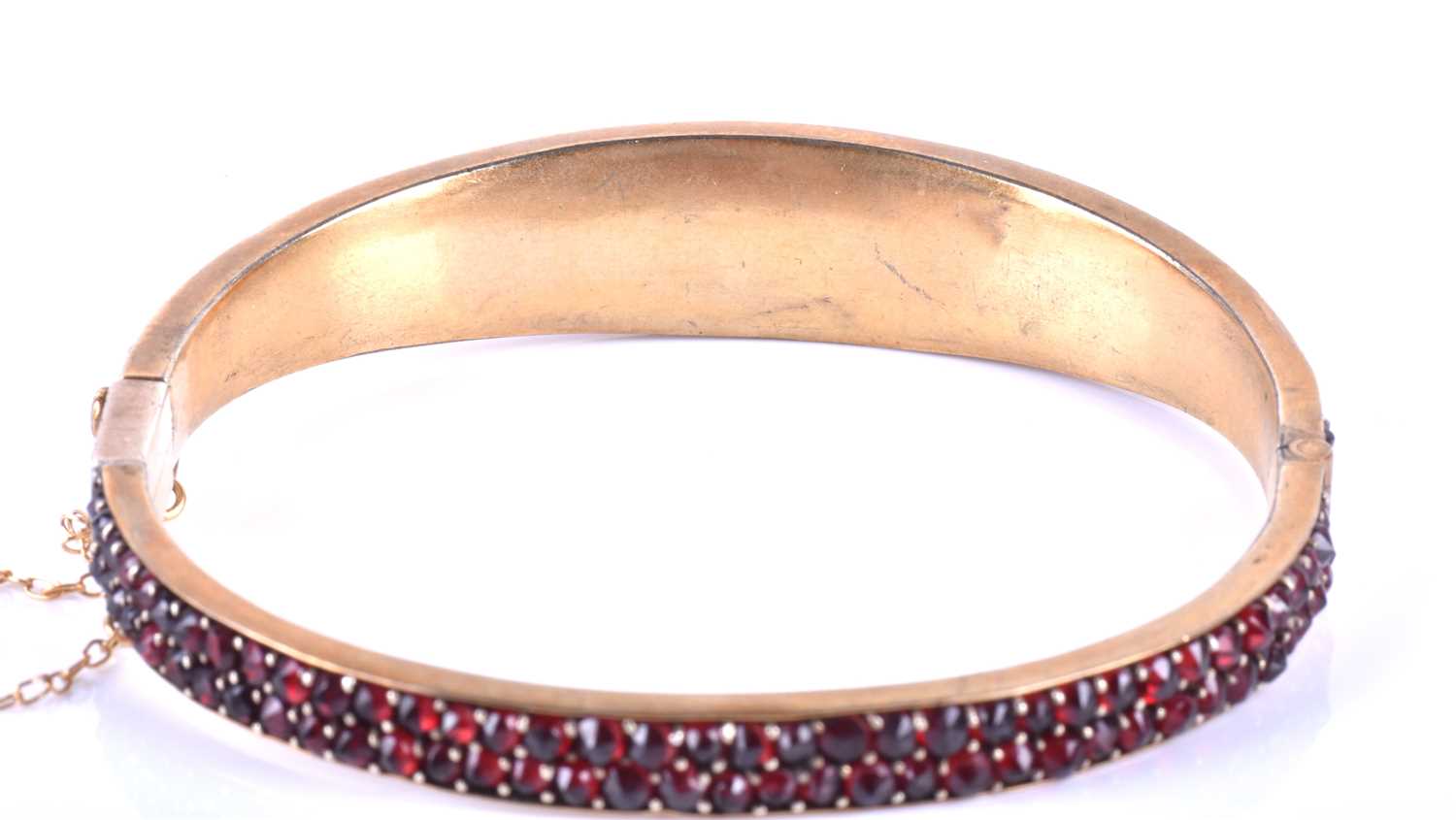 A late Victorian garnet bracelet, the gilt metal hinged bangle set with five collet-set rose-cut - Image 8 of 8