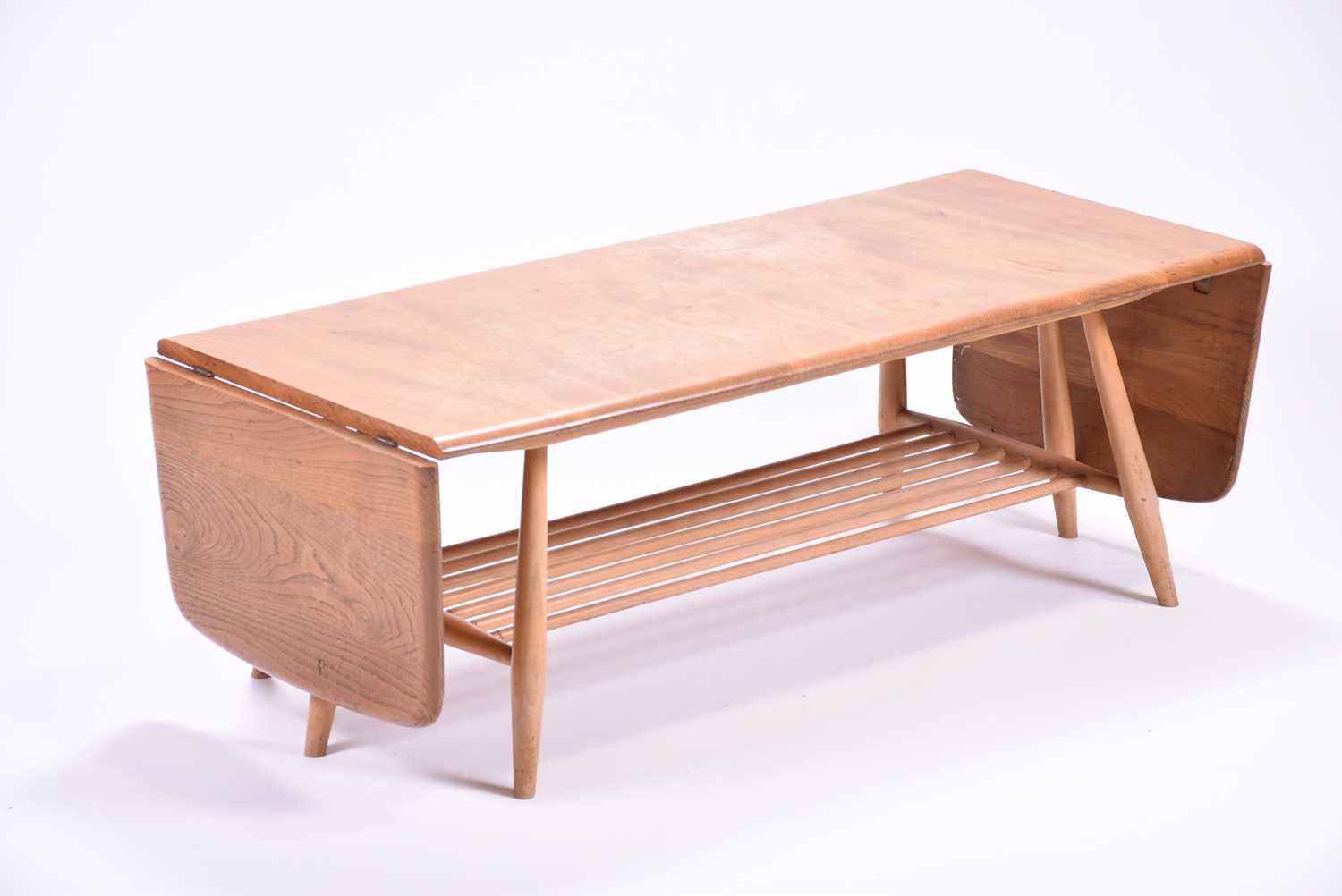 An Ercol extendable coffee table, with a pair of drop flaps and rack below. 108 cm wide, 46 cm deep,