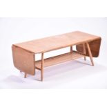 An Ercol extendable coffee table, with a pair of drop flaps and rack below. 108 cm wide, 46 cm deep,