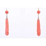 A pair of orange coral drop earrings,the tapered drops with carved decoration, suspended below a