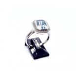 A 9ct white gold blue topaz and diamond ring, the central rubover set blue topaz weighing 2.71 carat