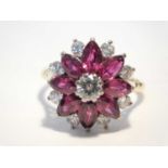 An 18ct gold Ruby and diamond daisy cluster ring, te stones set in a white metal mount with yellow