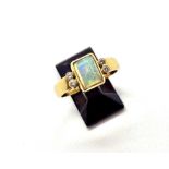 An 18ct yellow gold opal and diamond ring, the central rubover set opal with 4 rubover set brilliant