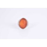 A white metal and carnelian ringset with an oval carnelian plaque engraved with Islamic script,