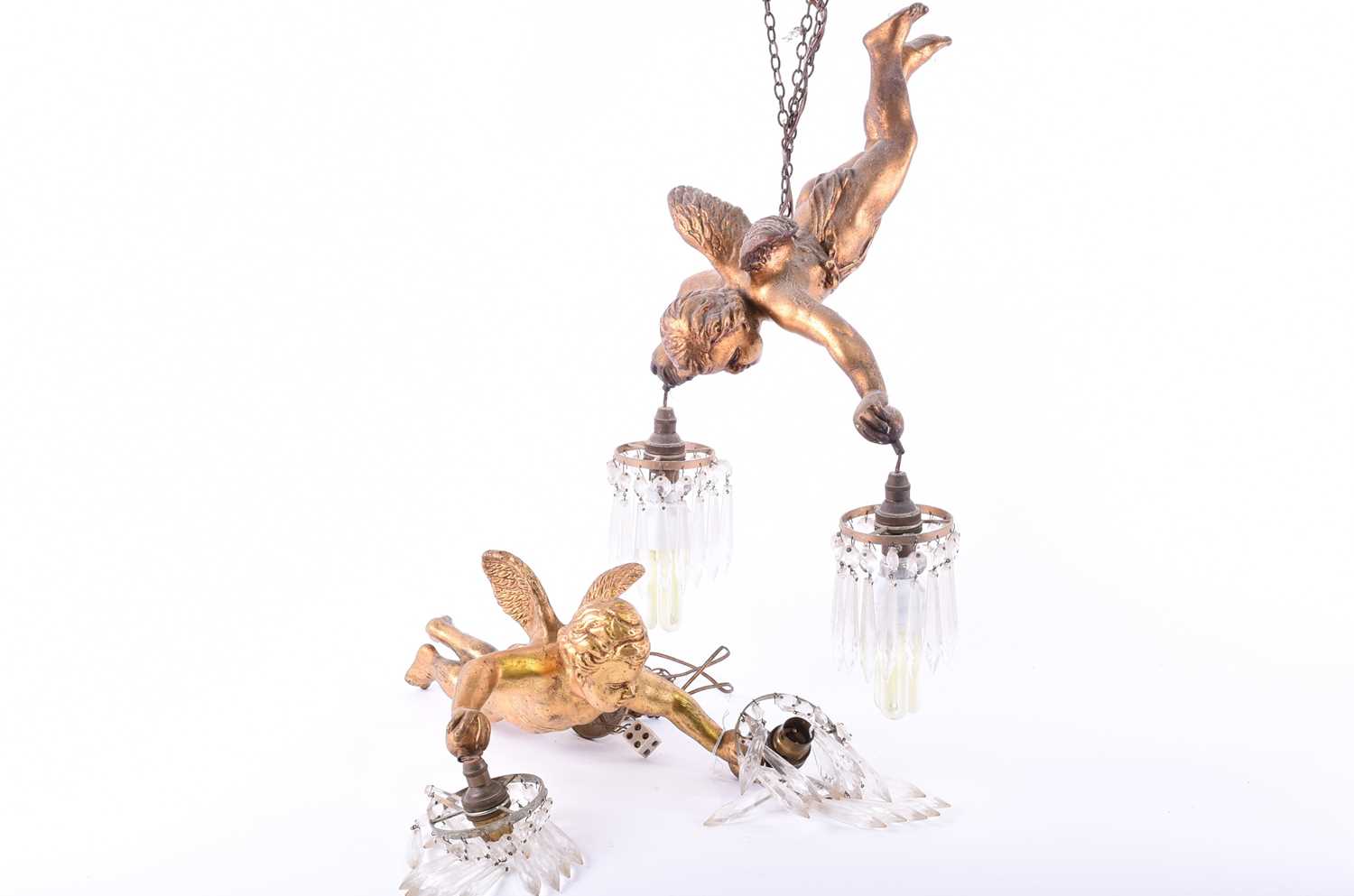 Two mid-20th century ceiling light pendantsmodelled as gilt putti, holding suspended lamp holders in - Image 2 of 4