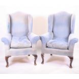 A pair of large 19th century wingback mahogany armchairswith later blue upholstery. 91 cm wide by