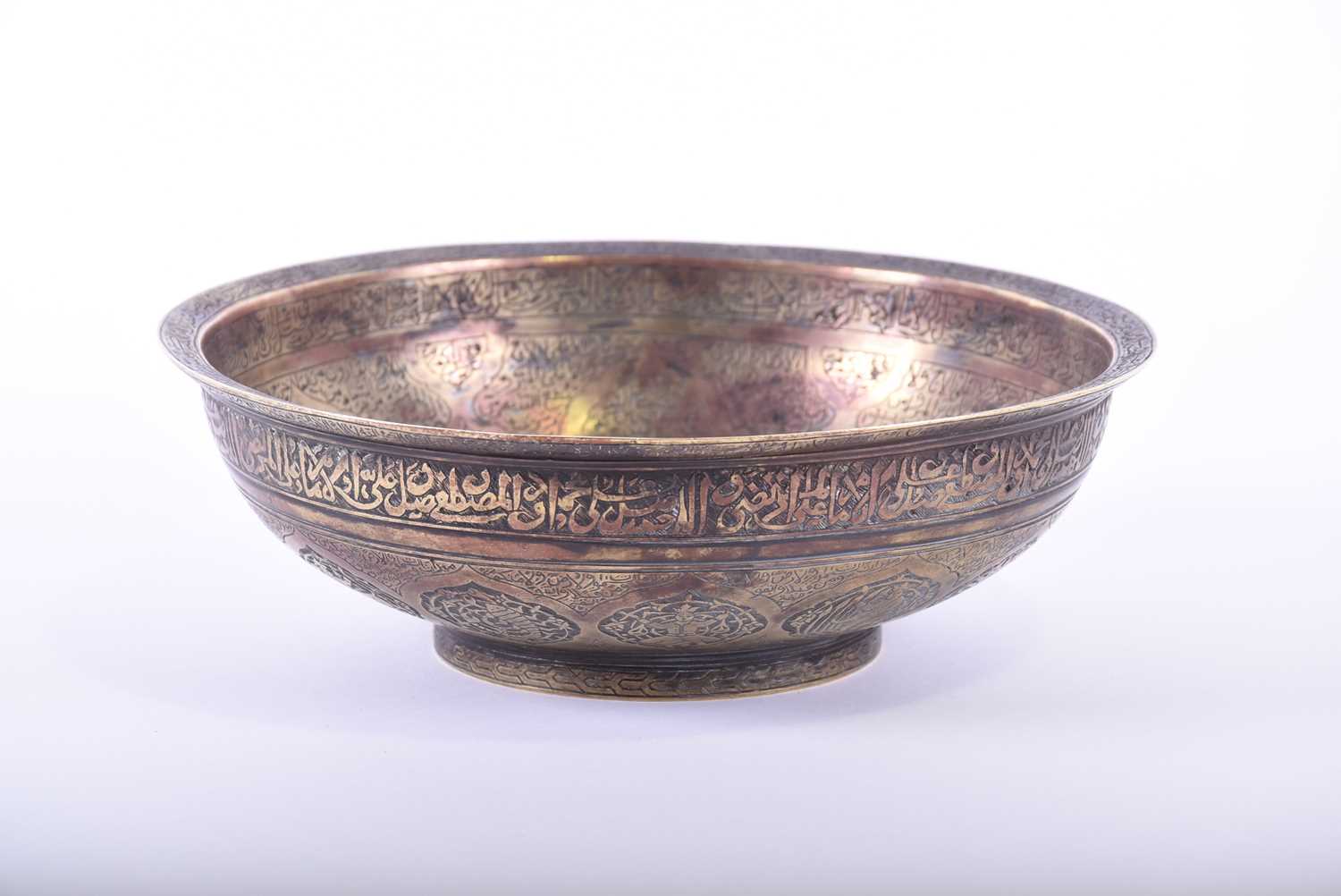 A Persian cast bronze calligraphic bowl, the interior with central raised boss, pierced at the