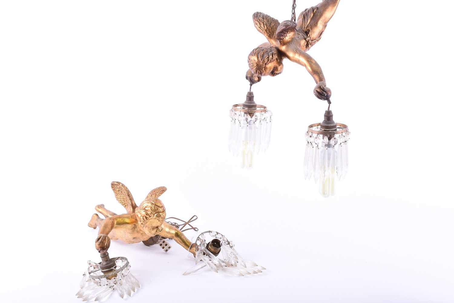 Two mid-20th century ceiling light pendantsmodelled as gilt putti, holding suspended lamp holders in