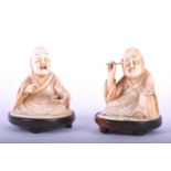 A pair of Japanese carved ivory okimono, c.1880, carved as a seated man picking wax from his ear,