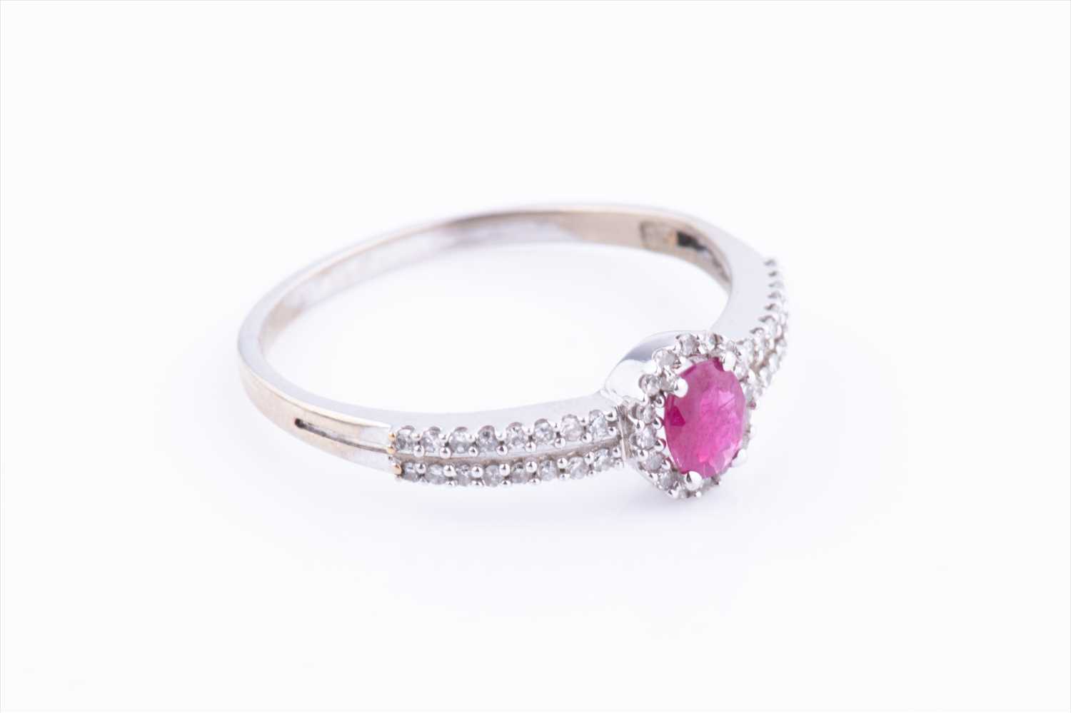 A diamond and ruby halo cluster ring, centred with an oval-cut ruby within a border of diamonds, the - Image 2 of 3