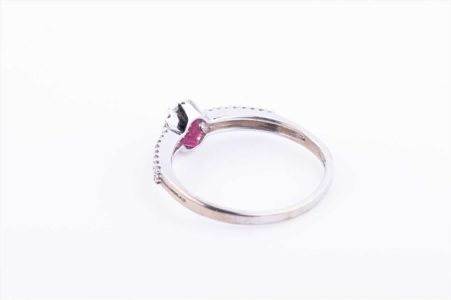 A diamond and ruby halo cluster ring, centred with an oval-cut ruby within a border of diamonds, the - Image 3 of 3
