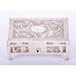 A Chinese carved ivory dressing table box, late 19th century, of rectangular form, the lid carved