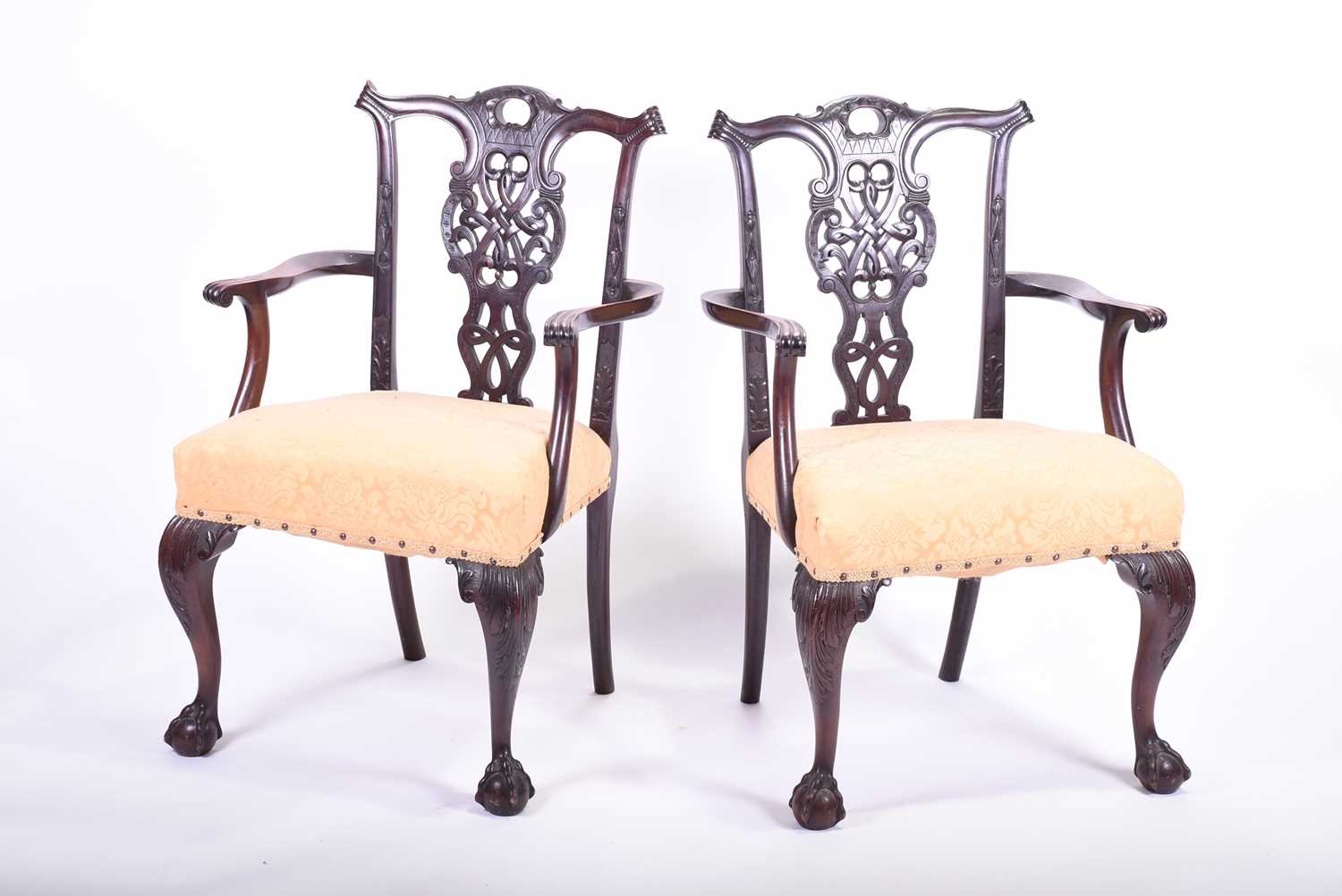 A pair of Georgian style mahogany elbow chairs, with carved and pierced back splats, yellow fabric