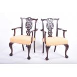 A pair of Georgian style mahogany elbow chairs, with carved and pierced back splats, yellow fabric