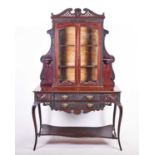 A late Victorian mahogany rococo revival display cabinet, with glazed cupboard doors above two