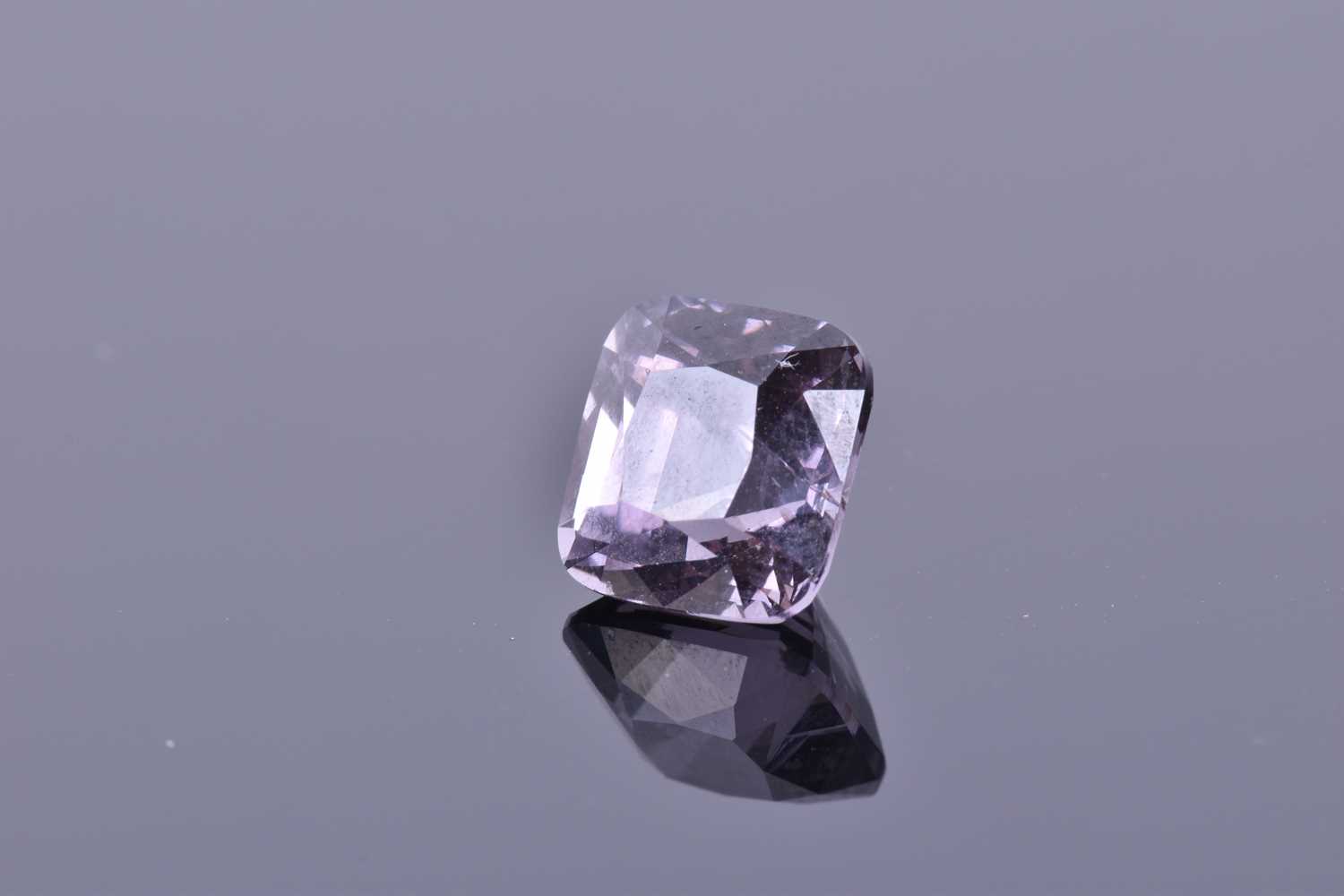 A loose square cushion-cut spinelmid to dark purple in colour, of 4.45 carats. Please note: VAT will