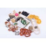 A group of costume jewellery itemsincluding various paste brooches, an amber necklace, beads, rings,