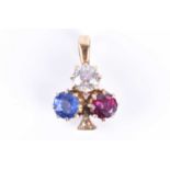 A diamond, sapphire, and ruby trefoil pendantset with an old-cut diamond of approximately 0.33