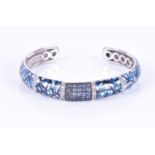 Danuta. A silver, diamond, sapphire, and enamel bangleof curved design, with blue, black and white