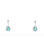A pair of white gold, diamond, and emerald drop earringseach set with a mixed pear-cut emerald,