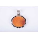 A Persian carnelian and silver pendantof oval form, engraved with Islamic script, 3.8 x 4.5 cm.