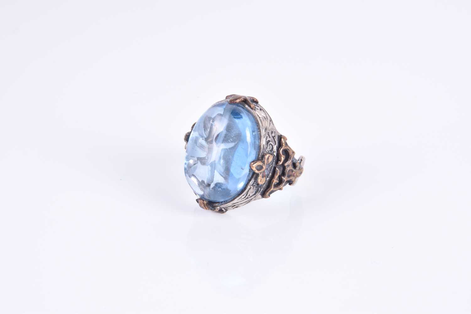 An unusual silver and blue glass ringset with an oval blue glass cabochon, of stylised