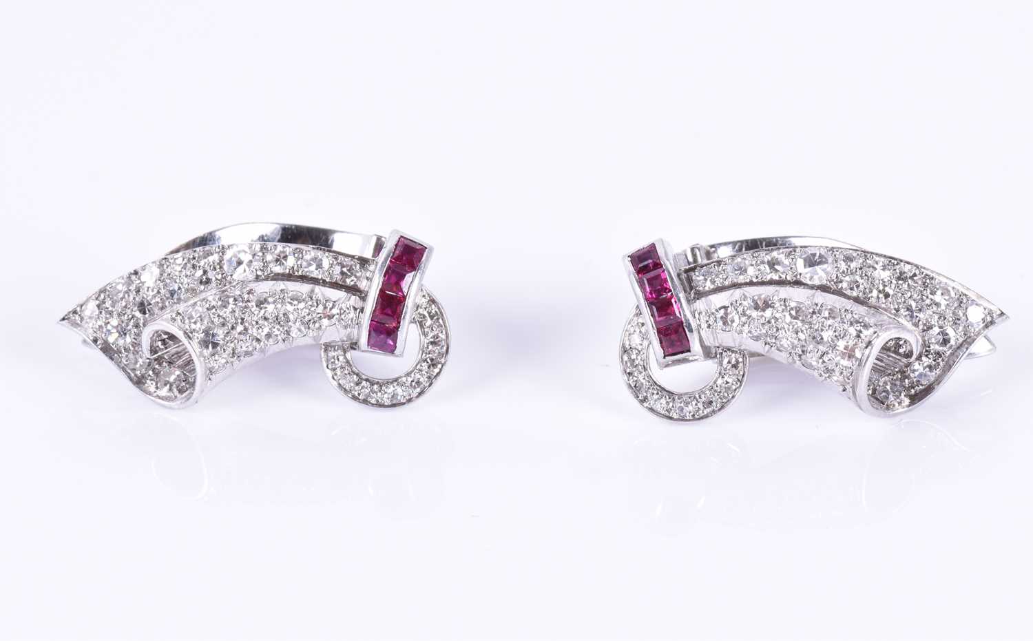 A pair of white gold, diamond, and ruby earringscirca 1950s, the swept mounts each with a row of