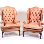 A pair of tan leather wingback armchairswith button backs and stud finish, early 20th century.85