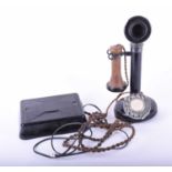 An early 20th century candlestick telephone with bakelite ear and adjustable mouthpiece, with