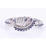 A white metal, diamond, and sapphire braceletthe swept central segment set with round brilliant-