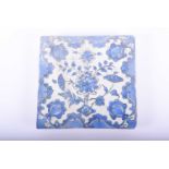 A Persian pottery blue and white tile, 18th/19th century, decorated with a central floral spay
