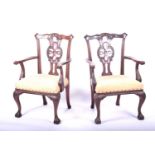 A pair of Georgian style mahogany elbow chairs, with carved and pierced back splats, yellow fabric