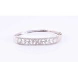A white metal and diamond bangle braceletthe openwork mount inset with round brilliant-cut