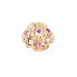 An unusual 1960s 18ct yellow gold, diamond, and ruby ringof Modernist design, the textured mount