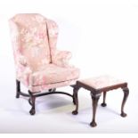 A 19th century Queen Anne style wing armchair upholstered in floral material with horsehair filling,