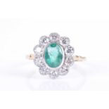A diamond and emerald cluster ringset with a mixed oval-cut emerald of approximately 1.0 carat,