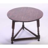 An 18th century oak cricket tableof typical form with circular top, joined by plain stretchers.75 cm