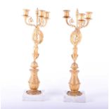 A pair of French Empire style gilt metal three branch candelabra, 19th century, after a design by