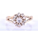 A yellow metal and diamond daisy cluster ring, centred with a rose-cut diamond surrounded with