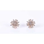 A pair of yellow metal and diamond earringsof circular starburst form, set with round brilliant-