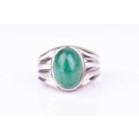 A white metal and emerald ringset with an oval cabochon emerald (treated), the shoulders with ribbed