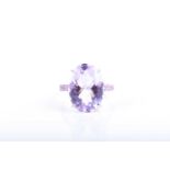 A white gold, kunzite, and pink sapphire ringset with a faceted oval-cut light purple kunzite of