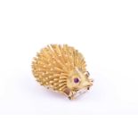 A mid 20th century yellow gold novelty brooch in the form of a hedgehog, with collet-set ruby