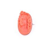 A late 19th century yellow metal mounted carved coral brooch depicting a woman's face in profile,